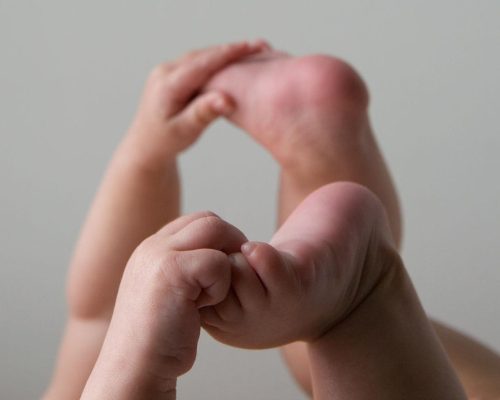 Baby holding feet, curling fingers and toes